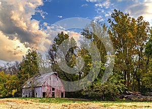 Old red wood barn in an autumn landscape