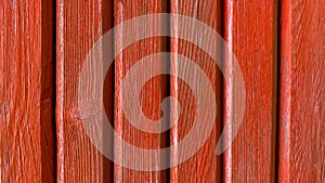 Old red wooden background of colored painted vertical boards in grunge style. Top view. Raw planed texture of coniferous