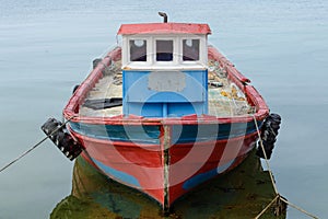 Old wooden fishing boat anchored at sea