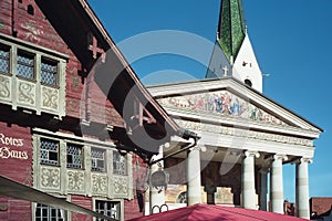 Old red wooden house and parish church