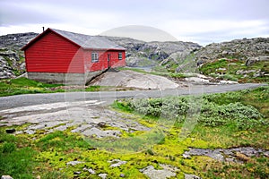 Old red wooden house in wild mountains