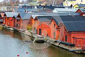 Old red wooden houses on the river coast on a cloudy day