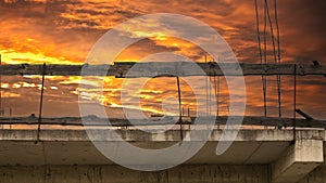 Old reinforced concrete floor with columns against the sunset sky. Dangerous abandoned building structure.