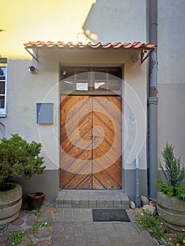 Old renovated wooden door entrance of a residential house with hanging post box on a wall on sunny day