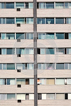 Old residential building facade with windows and air conditioners