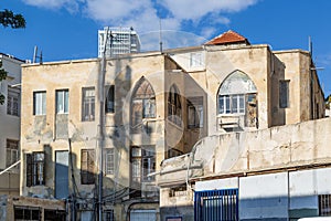 old residential building with weathered facade under clear blue sky in central Tel Aviv