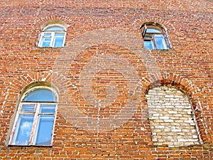 Old residential house, brick wall, arched windows, one bricked up window