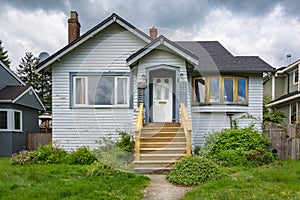 Old residential house with neglected lawn on the front yard.