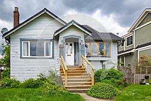 Old residential house with neglected lawn on the front yard.