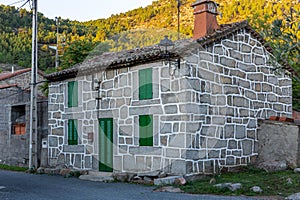 Old residential rural brick house with green doors and window shutters, Spain.