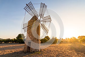 Old restored windmill in the countryside at sunset with the sun behind on the island of Majorca, Spain