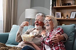 Old retired age couple watching TV at home, old mature couple cheering sport games competition together with laugh smile victory