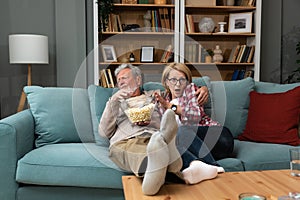 Old retired age couple watching TV at home, old mature couple cheering sport games competition together with laugh smile victory