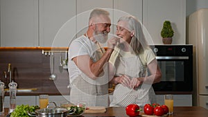 Old retired couple Caucasian family middle aged woman and man love cooking at home kitchen cut veggies healthy feed
