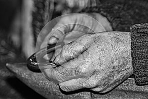Old retired man hands working in b&w