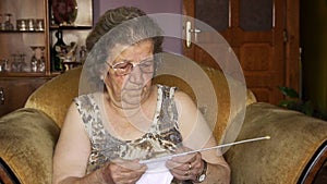 Old retired woman knitting in home