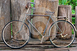 An old retro antique vintage bicycle leaning against wooden fence