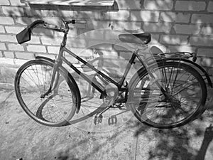 Old retro bicycle on brick wall. Photo in black and white style