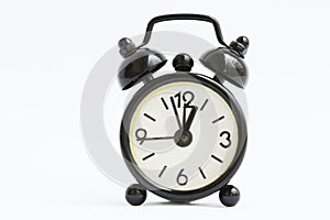 Old retro black alarm clock on isolated white background