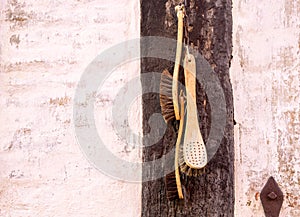 Old retro brushes hang decoratively on wooden wall