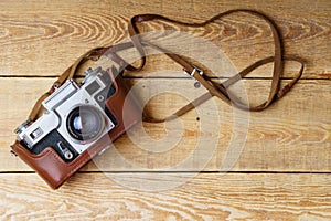Old retro camera on vintage rustic wooden planks boards. Education photography courses back to school concept abstract background