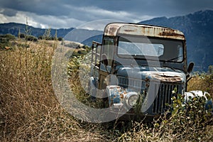 Old retro car on the mountain landscape background. Old car in a thunderstorm