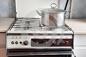 Old retro gas stove with pans and kettle. photo of obsolete kitchen utensils.