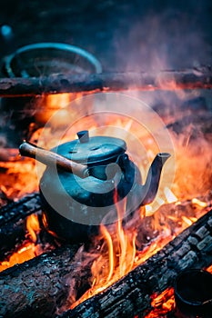 Old Retro Iron Camp Kettle Boiling Water On A Fire In Forest.