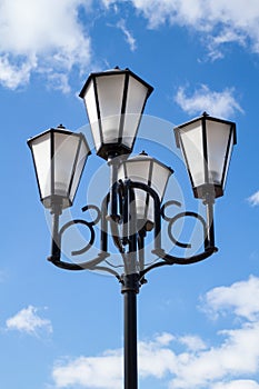 The old retro lamp post and the beautiful white and blue sky