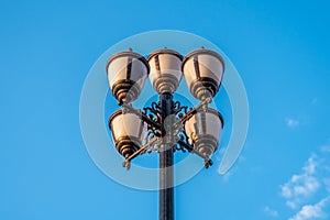 The old retro lamp post and the beautiful white and blue sky