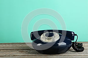 Old retro phone on grey wooden background.