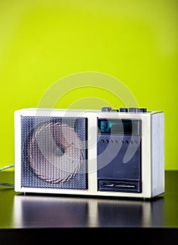 Old retro radio on table with green background