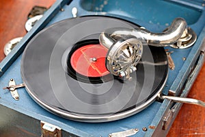 An old retro record playing on old vintage gramophone at flea market.