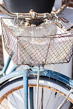 Old retro rusty bicycle with wire basket on handlebars