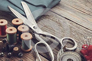 Old retro sewing accessories and green cloth.