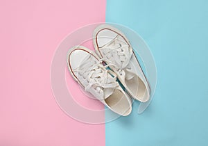 Old retro sneakers with white laces on a blue pink pastel background. Minimalism. Top View.