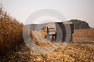 An old retro Soviet truck rides across a field for harvesting against a blue sky on a sunny day. Theme of transport and