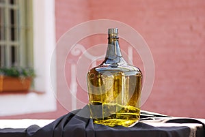 Old retro style demijohn for decoration of environments. Green bottle for wine or liquids.