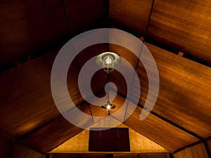 Old retro style lamp hanging on the ceiling inside the large glamping tent.