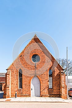 Old retro style white closed door on red brick wall of English building with David star on top window