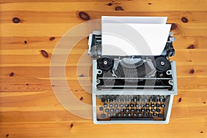 Old retro typewriter on wooden desk.