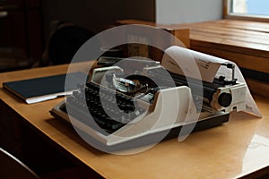 Old retro typewriter on the wooden desk