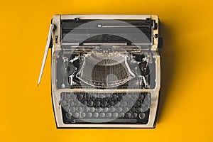 Old Retro Typewriter On A Yellow Background, Top View. Creative