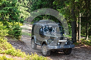 Old retro vintage 4x4 SUV on a dirt gravel dirt road in summer. Off-road car mountain safari adventure nature trip