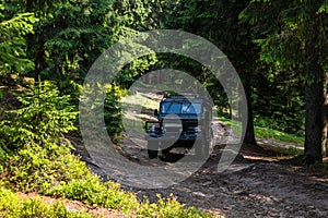 Old retro vintage 4x4 SUV on a dirt gravel dirt road in summer. Off-road car mountain safari adventure nature trip