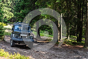 Old retro vintage 4x4 SUV on a dirt gravel dirt road in summer. Off-road car mountain safari adventure nature trip