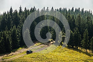 Old retro vintage 4x4 SUV on a dirt gravel dirt road in summer. Off-road car mountain safari adventure nature trip