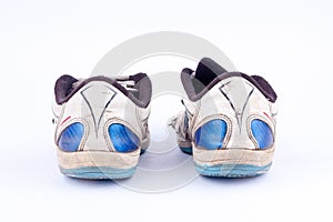 Old retro worn out futsal sports shoes on white background back view