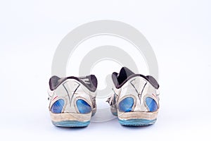 Old retro worn out futsal sports shoes on white background isolated back view
