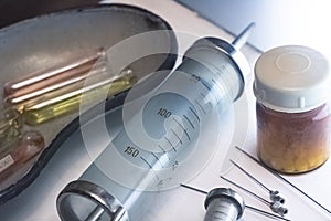 Old reusable syringe, needles and ampoules closeup